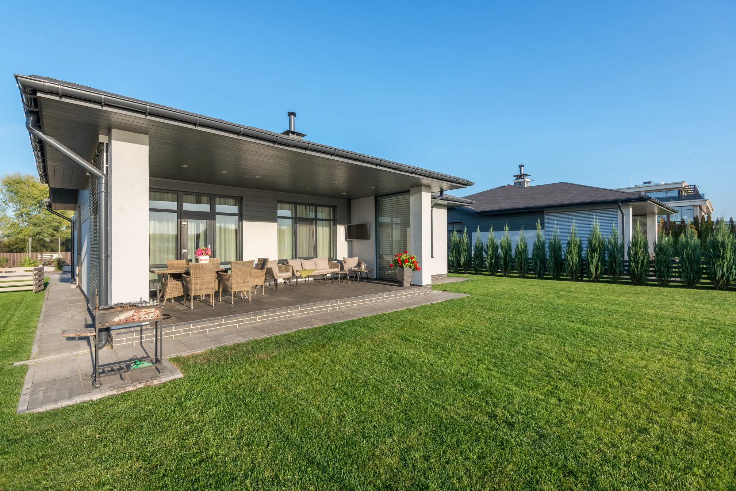Single story home with a covered patio and an even green lawn