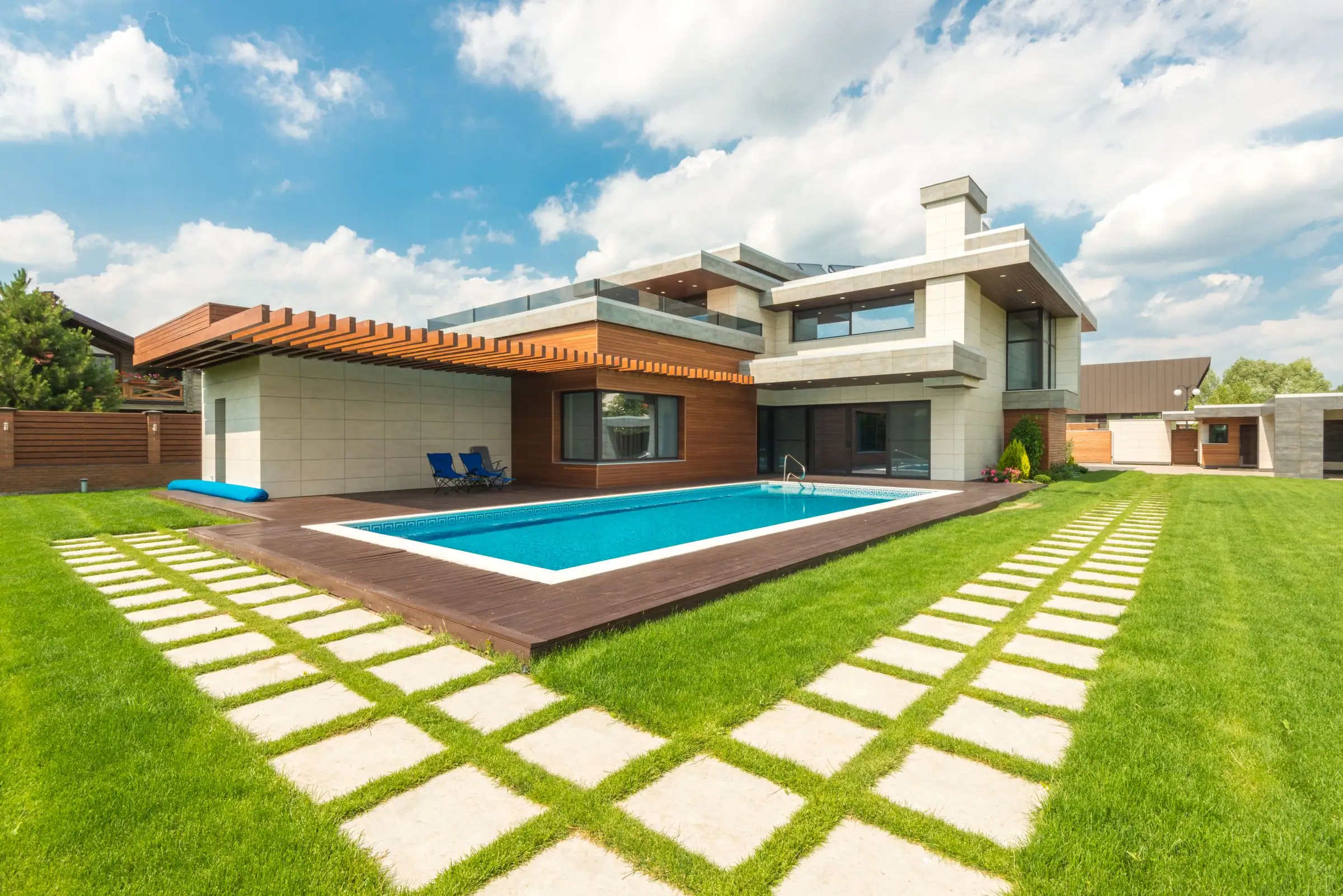 Backyard pool with a green lawn and paver stepping stones